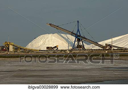 Stock Photo - "Heap of sea salt at the salt works Salins du Midi with an evaporation basin at front, Aigues-Mortes, Region Languedoc-Roussillon, France, Europe". Fotosearch