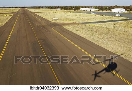 Stock Image - "Helicopter approaching the airport of Maun, Okavango Delta, Botswana, Africa". Fotosearch