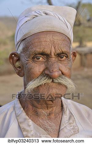 "Herdsman from the tribe of the Maldhari in a typical white robe and golden earrings, portrait, Gir Forest National Park, Gir Sanctuary, Dudhala, Gujarat, India, Asia" View Large Photo Image Stock Image - "Herdsman from the tribe of the Maldhari in a typical white robe and golden earrings, portrait, Gir Forest National Park, Gir Sanctuary, Dudhala, Gujarat, India, Asia". Fotosearch