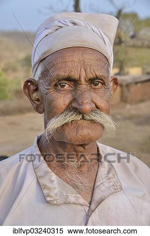 "Herdsman from the tribe of the Maldhari in a typical white robe and golden earrings, portrait, Gir Forest National Park, Gir Sanctuary, Dudhala, Gujarat, India, Asia" View Large Photo Image Stock Photography - "Herdsman from the tribe of the Maldhari in a typical white robe and golden earrings, portrait, Gir Forest National Park, Gir Sanctuary, Dudhala, Gujarat, India, Asia". Fotosearch