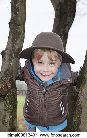 "High-spirited boy, 5, wearing a hat, on a tree" View Large Photo Image Stock Photo - "High-spirited boy, 5, wearing a hat, on a tree". Fotosearch