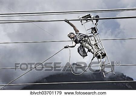 Stock Photo - "High-voltage service technician pulling a rope to get to the next pylon, Wiesing, Schwaz District, North Tirol, Tirol, Austria, Europe". Fotosearch