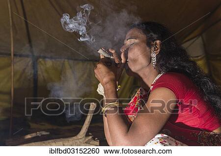 Stock Image - "Hijra, eunuch, smoking marihuana during Kumbha Mela, Allahabad, Uttar Pradesh, India, Asia". Fotosearch