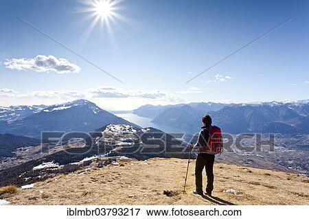 Stock Photo - "Hiker ascending Monte Stivo mountain, overlooking Lake Garda, Trentino, Italy, Europe". Fotosearch