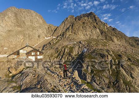 Stock Image - "Hiker at Rifugio Pagari mountain hut, Parco naturale delle Alpi Marittime nature reserve, bei Entracque, Cuneo province, Piedmont, Italy, Europe". Fotosearch