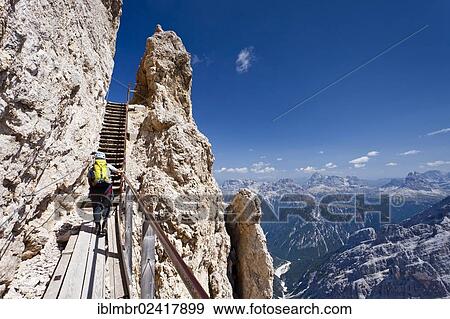 Hiker climbing Monte Cristallino mountain, here on the Ivano Dibona fixed rope route on Cristallo mountain above Cortina, Belluno, Dolomites, Italy, Europe View Large Photo Image Stock Photo - Hiker climbing Monte Cristallino mountain, here on the Ivano Dibona fixed rope route on Cristallo mountain above Cortina, Belluno, Dolomites, Italy, Europe. Fotosearch