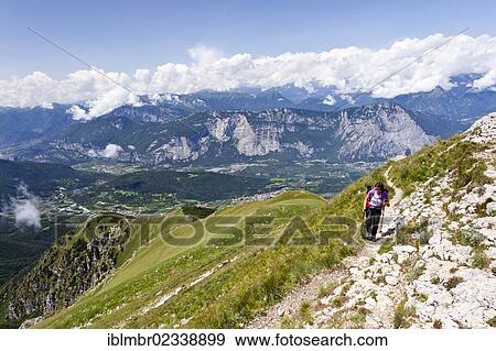 "Hiker during the ascent of Cornetto Mountain, overlooking the Sarca Valley, Trentino, Italy, Europe" View Large Photo Image Stock Photo - "Hiker during the ascent of Cornetto Mountain, overlooking the Sarca Valley, Trentino, Italy, Europe". Fotosearch