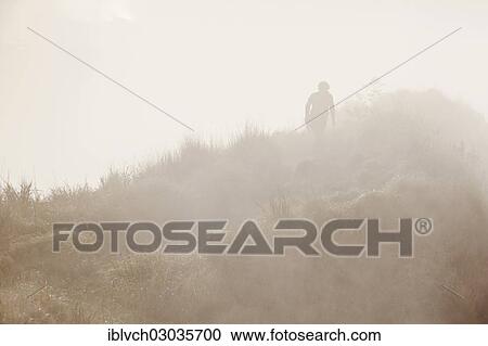 Stock Image - "Hiker in the mist on Gunung Agung volcano, Bangli, Bali, Indonesia, Asia". Fotosearch