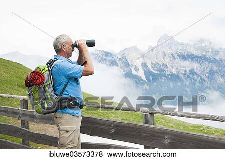 "Hiker looking at the Tannheim mountains with binoculars, Neunerkopfle, Tannheim Valley, Tyrol, Austria, Europe" View Large Photo Image Stock Photo - "Hiker looking at the Tannheim mountains with binoculars, Neunerkopfle, Tannheim Valley, Tyrol, Austria, Europe". Fotosearch