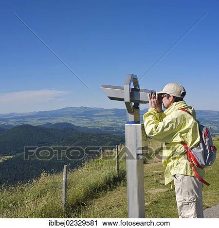 "Hiker looking through a telescope, Auvergne Volcanoes Regional Nature Park, France, Europe" View Large Photo Image Stock Image - "Hiker looking through a telescope, Auvergne Volcanoes Regional Nature Park, France, Europe". Fotosearch