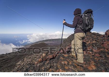 "Hiker on the summit of the Piton de la Fournaise volcano with views of clouds and the sea, Reunion, Africa" View Large Photo Image Stock Photo - "Hiker on the summit of the Piton de la Fournaise volcano with views of clouds and the sea, Reunion, Africa". Fotosearch