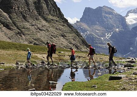 "Hiker rambling in the Rocky Mountains crossing a small lake, Banff National Park, Alberta Province, Canada, North America" View Large Photo Image Stock Photo - "Hiker rambling in the Rocky Mountains crossing a small lake, Banff National Park, Alberta Province, Canada, North America". Fotosearch