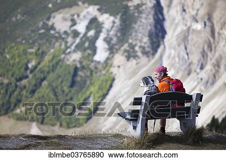 "Hiker sitting on a bench next to his dog, near Livigno, Sondrio province, Lombardy, Italy, Europe" View Large Photo Image Stock Image - "Hiker sitting on a bench next to his dog, near Livigno, Sondrio province, Lombardy, Italy, Europe". Fotosearch