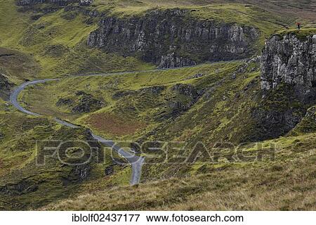 "Hiker standing in a volcanic landscape with a mountain pass road, Loch Leum na Luirginn, Flodigarry, The Table, Highlands, Isle of Skye, Scotland, United Kingdom, Europe" View Large Photo Image Stock Photo - "Hiker standing in a volcanic landscape with a mountain pass road, Loch Leum na Luirginn, Flodigarry, The Table, Highlands, Isle of Skye, Scotland, United Kingdom, Europe". Fotosearch