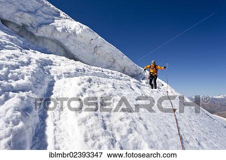 Stock Photo - "Hiker standing next to a crevasse, descending from Monte Cevedale mountain, province of Bolzano-Bozen, Italy, Europe". Fotosearch