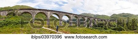 "Hiker under Glenfinnan Viaduct, arched railway bridge on West Highland Line, Lochaber, Scotland, United Kingdom, Europe" View Large Photo Image Stock Photograph - "Hiker under Glenfinnan Viaduct, arched railway bridge on West Highland Line, Lochaber, Scotland, United Kingdom, Europe". Fotosearch