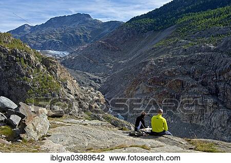 Stock Image - "Hikers at the Gletschertor lookout, view of Massa Gorge, Aletsch Glacier at the back, Belalp tourism region, Canton of Valais, Switzerland, Europe". Fotosearch