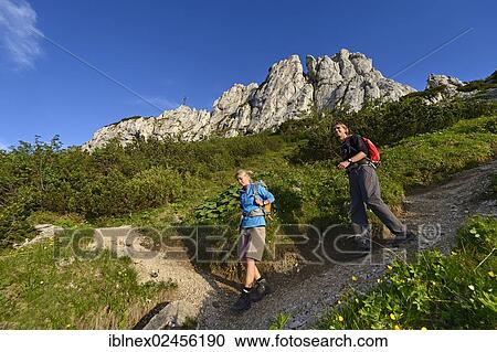 "Hikers descending in front of Kampenwand Mountain, Chiemgau, Bavaria, Germany, Europe" View Large Photo Image Stock Image - "Hikers descending in front of Kampenwand Mountain, Chiemgau, Bavaria, Germany, Europe". Fotosearch