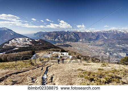 "Hikers during the ascent to Monte Stivo above St. Barbara, Lake Garda and the village of Riva at the rear, the village of Arco below, Trentino, Italy, Europe" View Large Photo Image Stock Photography - "Hikers during the ascent to Monte Stivo above St. Barbara, Lake Garda and the village of Riva at the rear, the village of Arco below, Trentino, Italy, Europe". Fotosearch