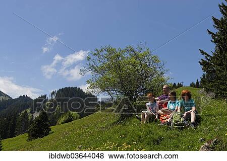 Stock Photo - "Hikers, father, 45, daughters, 11, son, 13, resting on the Kappeler Alp, Nesselwang, Swabia, Bavaria, Germany, Europe". Fotosearch