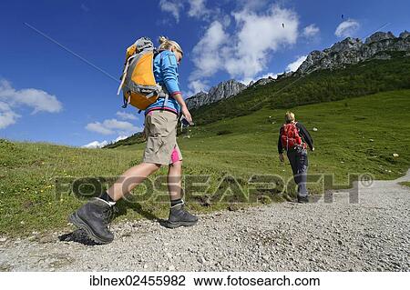 Stock Image - "Hikers in front of Kampenwand Mountain, Chiemgau, Bavaria, Germany, Europe". Fotosearch