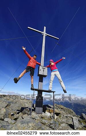 "Hikers on the summit cross on the summit of Boeses Weibele Mountain in the Defregger Group, Carnic Dolomites, Upper Lienz, Puster Valley, East Tyrol, Austria, Europe" View Large Photo Image Stock Photo - "Hikers on the summit cross on the summit of Boeses Weibele Mountain in the Defregger Group, Carnic Dolomites, Upper Lienz, Puster Valley, East Tyrol, Austria, Europe". Fotosearch
