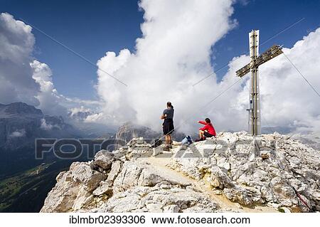 Stock Photograph - "Hikers on the summit of Sasshongher mountain above Corvara, Sellastock mountain and Passo Gardena ridge at the back, Puez group, Puez-Geisler Nature Park, Dolomites, province of Bolzano-Bozen, Italy, Europe". Fotosearch