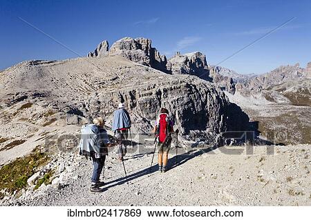 Hikers walking on Buellelejoch mountain, Paternkofel mountain and Dreizinnenhuette mountain shelter at the back, Hochpustertal valley, Sexten, Dolomites, province of Bolzano-Bozen, Italy, Europe View Large Photo Image Stock Photo - Hikers walking on Buellelejoch mountain, Paternkofel mountain and Dreizinnenhuette mountain shelter at the back, Hochpustertal valley, Sexten, Dolomites, province of Bolzano-Bozen, Italy, Europe. Fotosearch