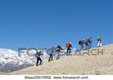 Stock Image - "Hiking group during the ascent, snow-capped mountains, Mustang Himal mountain range, Lo Manthang, Upper Mustang, Nepal, Asia". Fotosearch