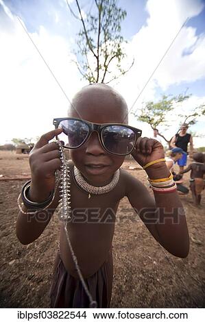 "Himba child wearing traditional clothes and sunglasses in a typical village near Kamanjab, Namibia, Africa" View Large Photo Image Picture - "Himba child wearing traditional clothes and sunglasses in a typical village near Kamanjab, Namibia, Africa". Fotosearch