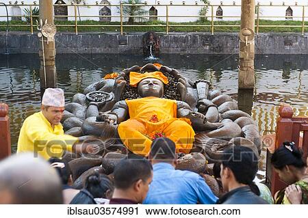 Stock Image - "Hindu pilgrims and a brahman at a depiction of Lord Vishnu as Jalashayana Narayan lying in the water, Budhanilkantha, Kathmandu District, Bagmati Zone, Nepal, Asia". Fotosearch