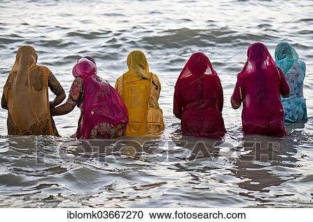 "Hindu pilgrims, women in colourful saris taking a holy bath om the sea before sunrise, at the Ghat Agni Theertham, Rameswaram, Pamban Island, Tamil Nadu, India, Asia" View Large Photo Image Stock Image - "Hindu pilgrims, women in colourful saris taking a holy bath om the sea before sunrise, at the Ghat Agni Theertham, Rameswaram, Pamban Island, Tamil Nadu, India, Asia". Fotosearch