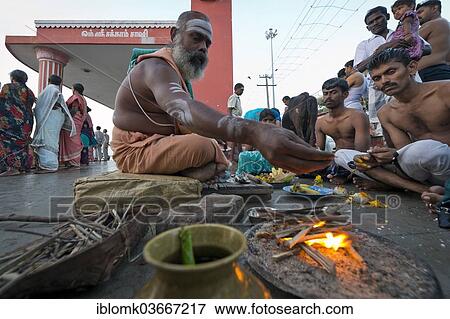 "Hindu priest with pilgrims performing a fire ritual at the Ghat Agni Theertham, Rameswaram, Pamban Island, Tamil Nadu, India, Asia" View Large Photo Image Stock Photo - "Hindu priest with pilgrims performing a fire ritual at the Ghat Agni Theertham, Rameswaram, Pamban Island, Tamil Nadu, India, Asia". Fotosearch