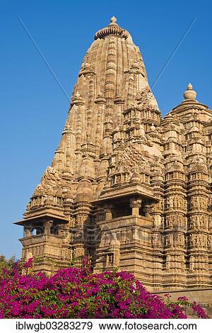 Stock Photo - "Hindu temple with flowering bougainvillea, Western Group, Kandariya Mahadeva Temple, Khajuraho Group of Monuments, UNESCO World Heritage Site, Khajuraho, Madhya Pradesh, India, Asia". Fotosearch