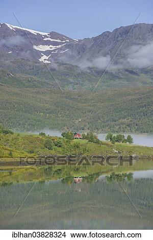 Picture - "Holiday cottage and mountains in Lakselvbukta Bay, Troms, Norway, Europe". Fotosearch