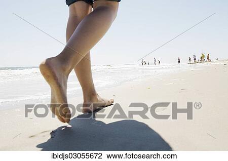 Stock Image - "Holiday maker walking barefoot along the beach, Westerland, Sylt, North Frisian Islands, Schleswig-Holstein, Germany, Europe". Fotosearch
