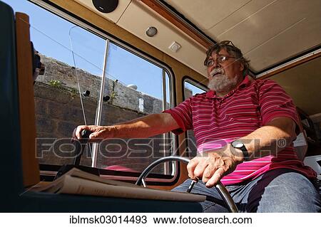"Holidaymaker at the wheel of a Penichette in the lock chamber, houseboat on the Canal des Vosges, formerly Canal de l'Est, Lock 45 at Corre, PK 146, Corre, Vesoul, Region Franche-Comte, Dep. Haute-Saone, France, Europe" View Large Photo Image Stock Image - "Holidaymaker at the wheel of a Penichette in the lock chamber, houseboat on the Canal des Vosges, formerly Canal de l'Est, Lock 45 at Corre, PK 146, Corre, Vesoul, Region Franche-Comte, Dep. Haute-Saone, France, Europe". Fotosearch