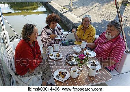 "Holidaymakers drinking coffee on the rear terrace of a Penichette, a houseboat on the Canal des Vosges, formerly Canal de l'Est, in the port, Corre, Vesoul, Region Franche-Comte, Dep. Haute-Saone, France, Europe" View Large Photo Image Stock Photograph - "Holidaymakers drinking coffee on the rear terrace of a Penichette, a houseboat on the Canal des Vosges, formerly Canal de l'Est, in the port, Corre, Vesoul, Region Franche-Comte, Dep. Haute-Saone, France, Europe". Fotosearch