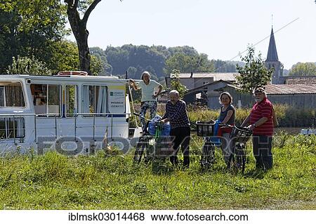 "Holidaymakers in front of a house boat on the Canal des Vosges, formerly Canal de l'Est, after going shopping by bicycle, Girancourt, Epinal, Lorraine, Departement Vosges, France, Europe" View Large Photo Image Stock Photo - "Holidaymakers in front of a house boat on the Canal des Vosges, formerly Canal de l'Est, after going shopping by bicycle, Girancourt, Epinal, Lorraine, Departement Vosges, France, Europe". Fotosearch