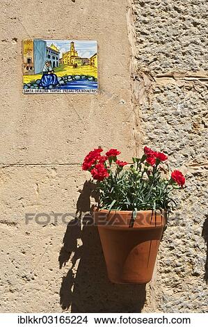 Picture - "Holy image and a flower pot on a house wall, Valldemossa, Majorca, Balearic Islands, Spain, Europe". Fotosearch