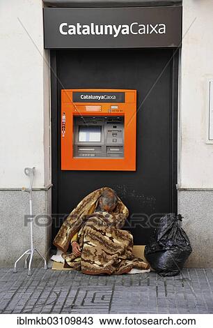 "Homeless man sitting wrapped in a blanket in front of an ATM of the Spanish bank CatalunyaCaixa, El Puerto de Santa Maria, Cadiz province, Andalusia, Spain, Europe" View Large Photo Image Stock Image - "Homeless man sitting wrapped in a blanket in front of an ATM of the Spanish bank CatalunyaCaixa, El Puerto de Santa Maria, Cadiz province, Andalusia, Spain, Europe". Fotosearch