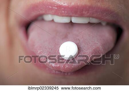 Stock Photography - Homeopathic Schuessler salt tablet on a tongue. Fotosearch