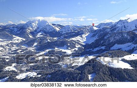 Stock Image - "Hot air balloon flying over the Alps, Unterinntal, Tyrol, Austria, Europe". Fotosearch