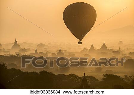Picture - "Hot air balloon over the landscape in the early morning fog, temples, stupas, pagodas, temple complex, Plateau of Bagan, Mandalay Division, Burma or Myanmar". Fotosearch