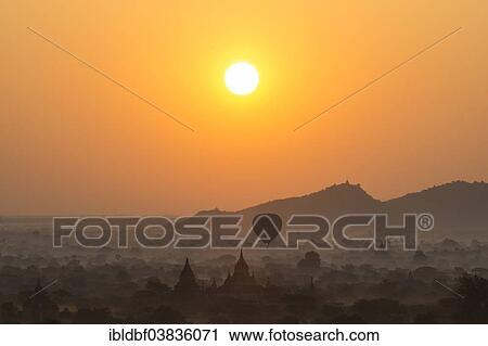"Hot air balloon over the landscape in the early morning fog, sunrise, temples, stupas, pagodas, temple complex, Plateau of Bagan, Mandalay Division, Burma or Myanmar" View Large Photo Image Stock Image - "Hot air balloon over the landscape in the early morning fog, sunrise, temples, stupas, pagodas, temple complex, Plateau of Bagan, Mandalay Division, Burma or Myanmar". Fotosearch