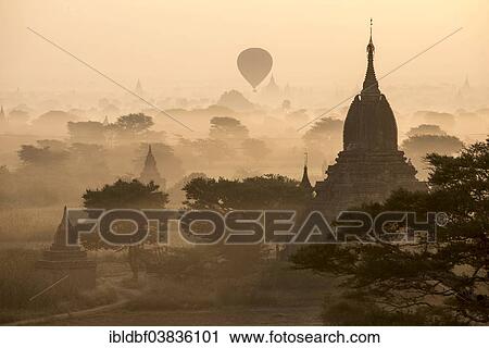 "Hot air balloon over the landscape in the early morning fog, temples, stupas, pagodas, temple complex, Plateau of Bagan, Mandalay Division, Burma or Myanmar" View Large Photo Image Stock Image - "Hot air balloon over the landscape in the early morning fog, temples, stupas, pagodas, temple complex, Plateau of Bagan, Mandalay Division, Burma or Myanmar". Fotosearch
