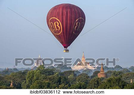 "Hot air balloon over the landscape in morning light, Ananda Temple, temple complex with a gold-plated tower structure or Shikhara, stupas, pagodas, temple complex, Plateau of Bagan, Mandalay Division, Burma or Myanmar" View Large Photo Image Stock Image - "Hot air balloon over the landscape in morning light, Ananda Temple, temple complex with a gold-plated tower structure or Shikhara, stupas, pagodas, temple complex, Plateau of Bagan, Mandalay Division, Burma or Myanmar". Fotosearch
