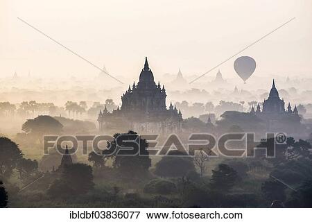 "Hot air balloon over the landscape in the early morning fog, temples, stupas, pagodas, temple complex, Plateau of Bagan, Mandalay Division, Burma or Myanmar" View Large Photo Image Stock Photo - "Hot air balloon over the landscape in the early morning fog, temples, stupas, pagodas, temple complex, Plateau of Bagan, Mandalay Division, Burma or Myanmar". Fotosearch