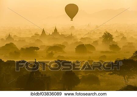 Stock Photo - "Hot air balloon over the landscape in the early morning fog, temples, stupas, pagodas, temple complex, Plateau of Bagan, Mandalay Division, Burma or Myanmar". Fotosearch