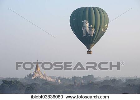 Stock Image - "Hot air balloon over the landscape, Ananda Temple, temple complex with a gold-plated tower structure or Shikhara, stupas, pagodas, Plateau of Bagan, Mandalay Division, Burma or Myanmar". Fotosearch